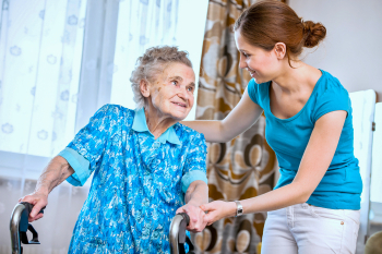 caregiver helping the senior woman to stand