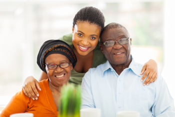 senior couple and a caregiver smiling